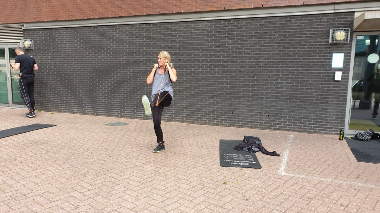 Deelneemster doet een balansoefening met het DISQ-systeem tegen een donkere muur